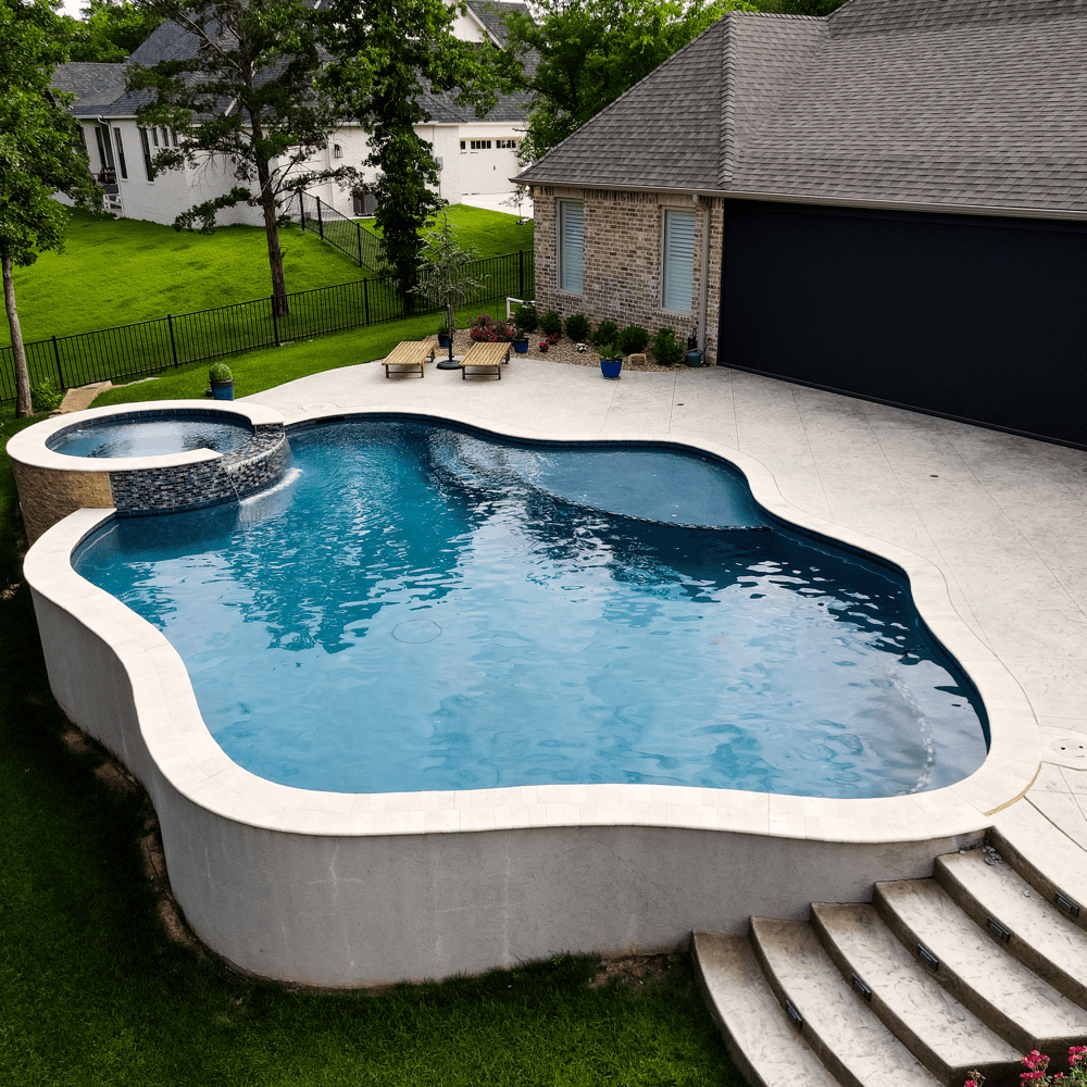 An ecoFINISH-coated pool and spa with a Mediterranean blue finish, showcasing the beautiful blue color of water. The view includes the surrounding deck area.