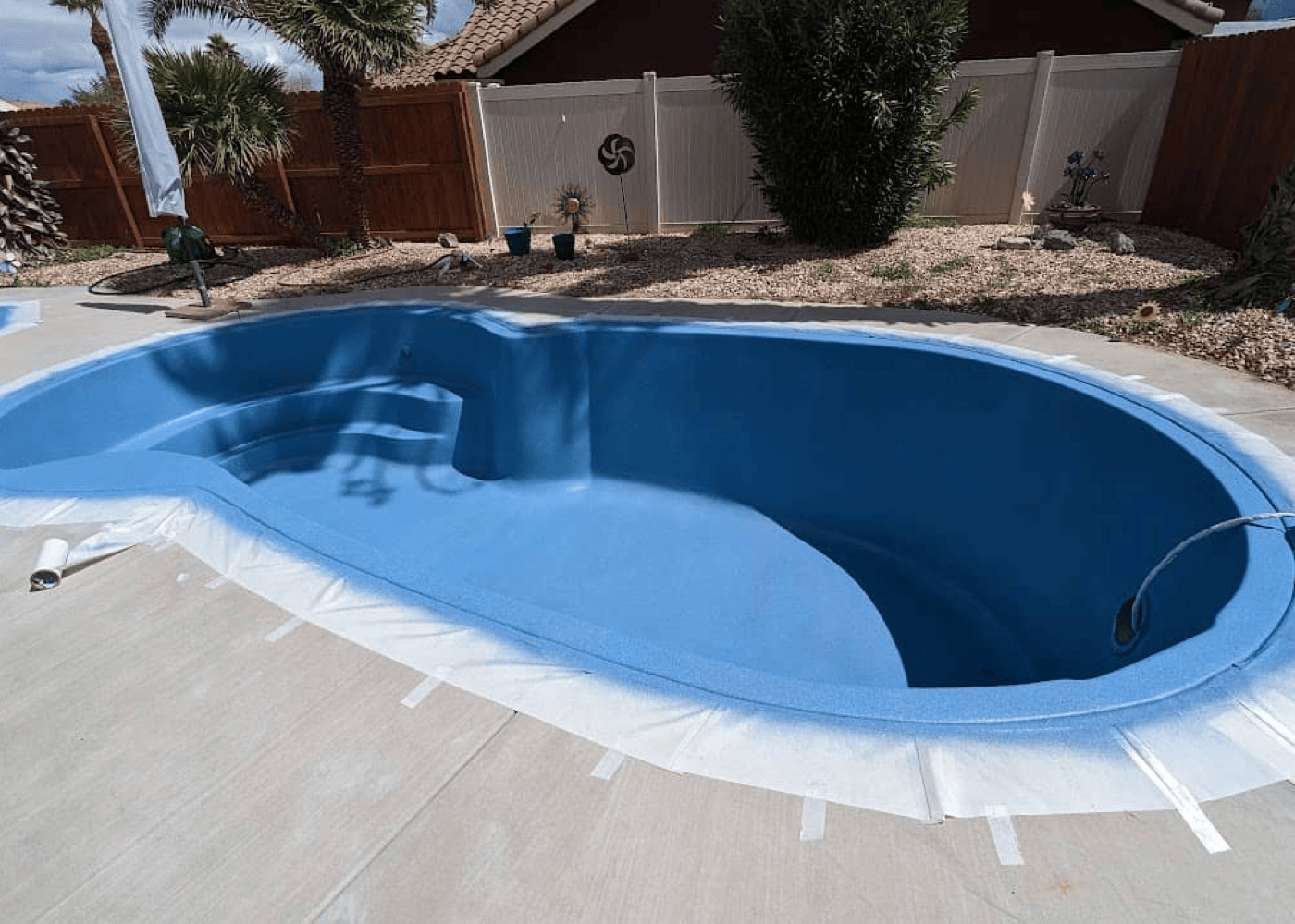 View of an empty in-ground pool, capturing the entire length of the pool.