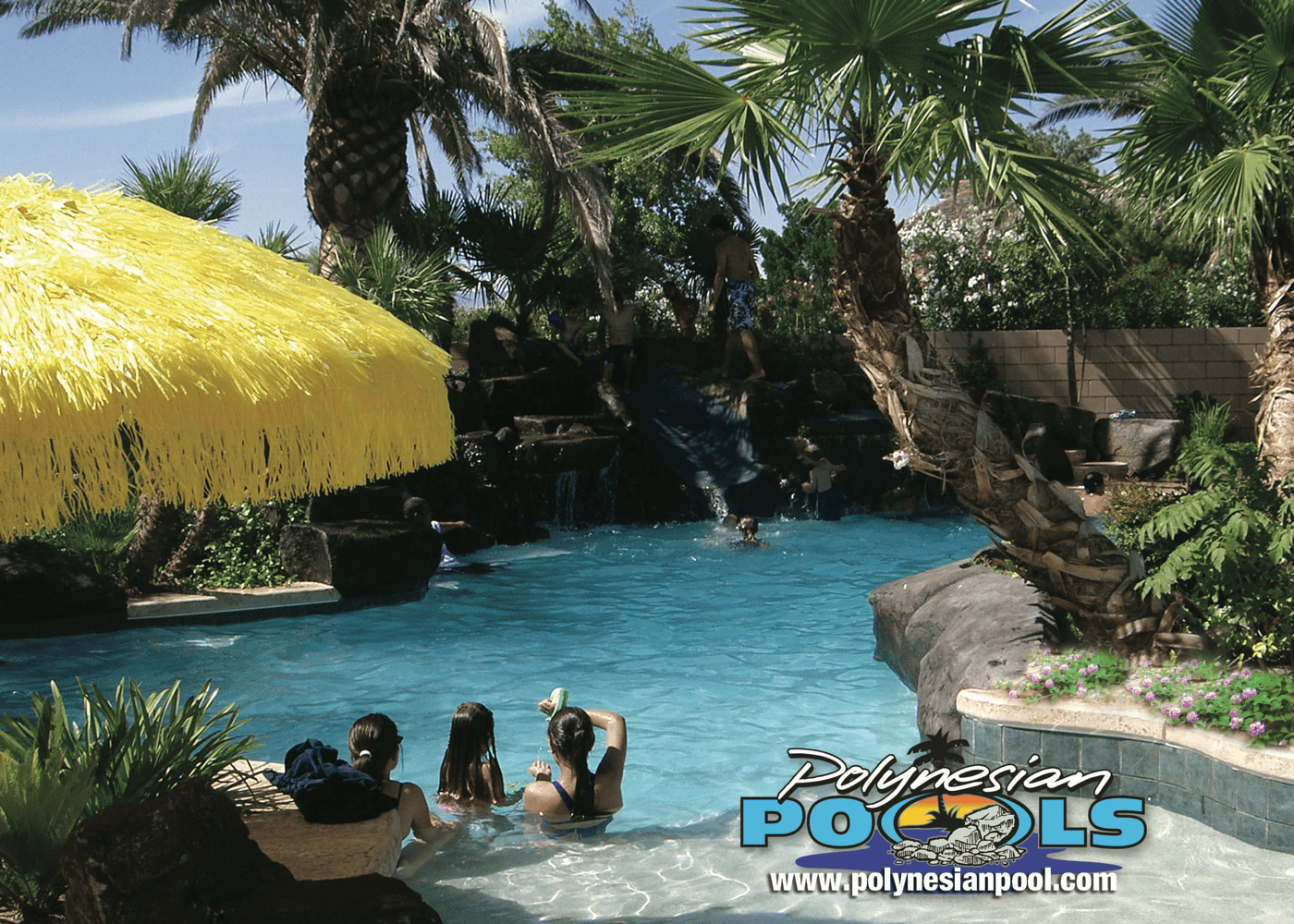 A view of an in-ground pool showcasing multiple features with a blend of hardscaping and greenery. The pool area includes various elements.