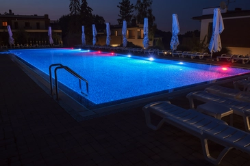 inground swimming pool lit up at night